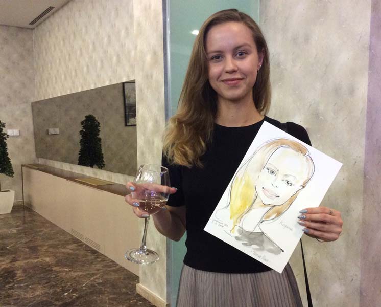 Карина держит свой шарж и бокал вина шаржист Михаил Шабалин Мишель Минск